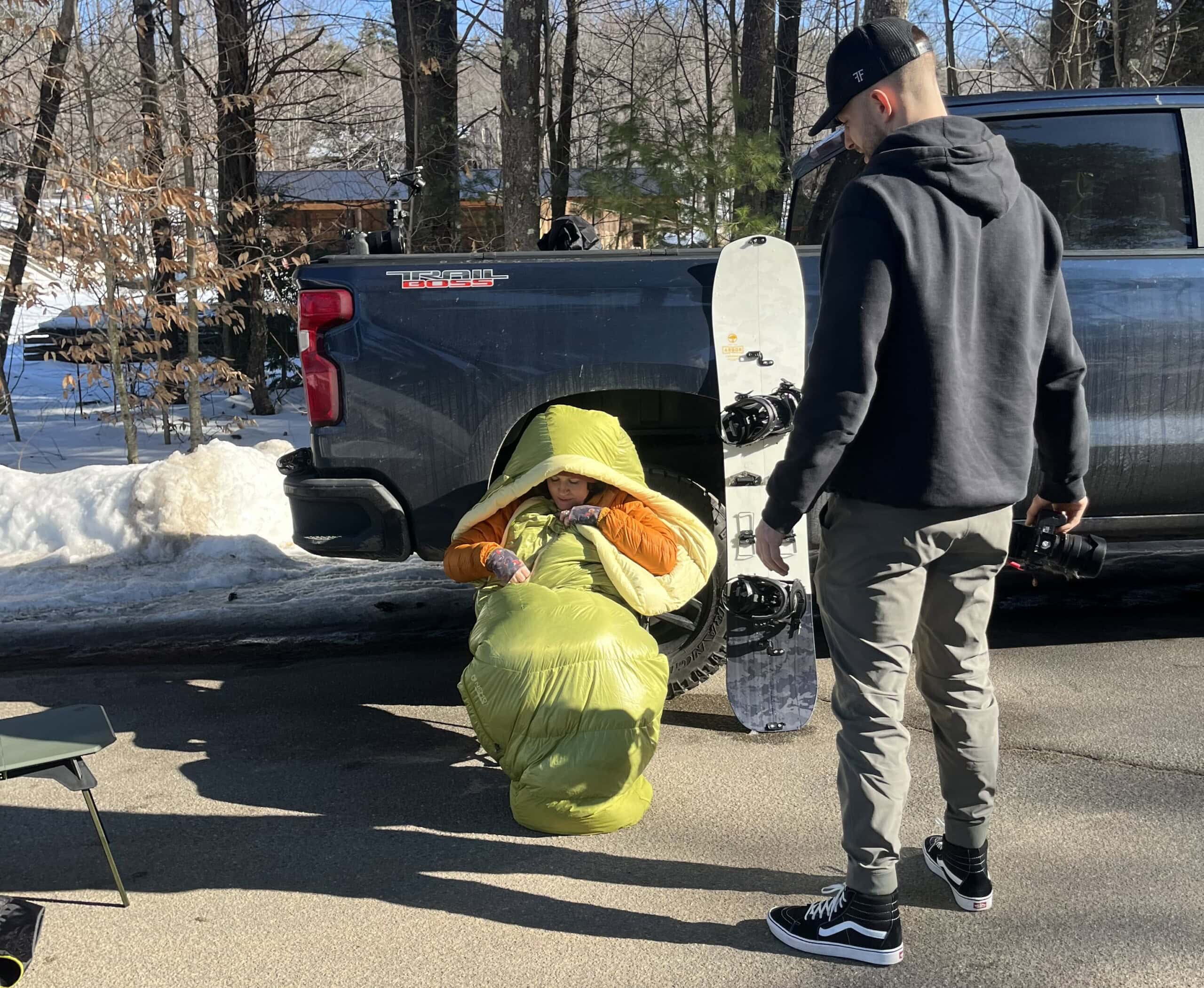 Woman in sleeping bag at trailhead